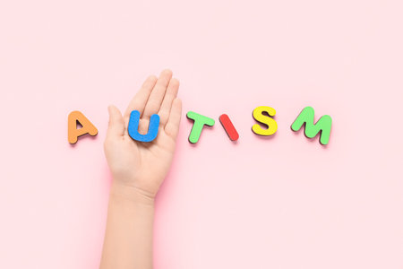 Child with word AUTISM on pink backgroundの写真素材