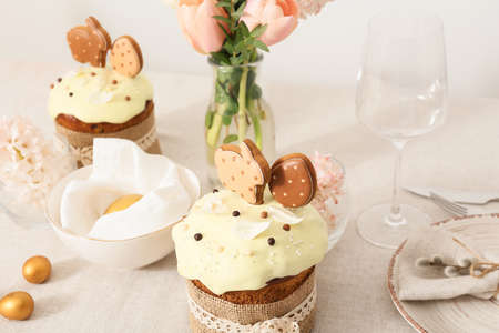 Beautiful setting with Easter cakes and eggs on light tablecloth, closeup