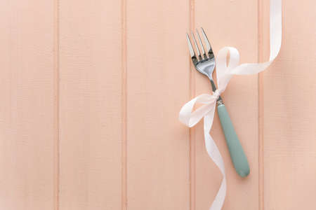 Fork with ribbon on pink backgroundの写真素材