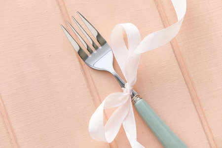 Fork with ribbon on pink backgroundの写真素材