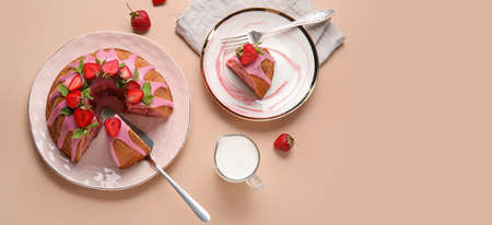 Tasty strawberry cake and jug of milk on color background