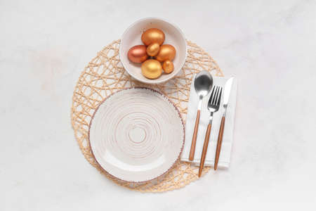 Beautiful table setting with Easter eggs on white background