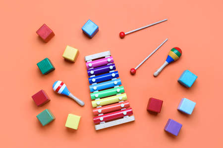 Wooden cubes with xylophone and rattles on red background