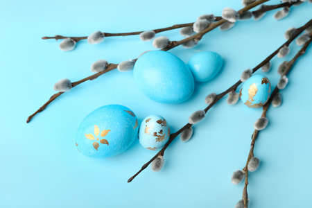 Painted Easter eggs and pussy willow branches on blue backgroundの写真素材
