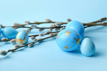 Painted Easter eggs and pussy willow branches on blue background