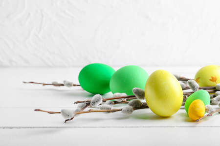 Painted Easter eggs and pussy willow branches on light wooden backgroundの写真素材