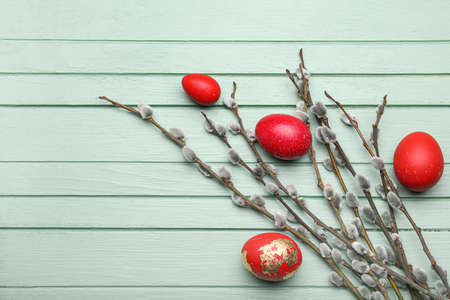 Painted Easter eggs and pussy willow branches on wooden background