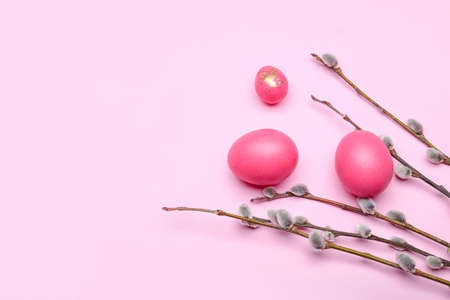 Painted Easter eggs and pussy willow branches on pink background