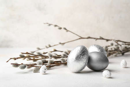 Easter eggs and pussy willow branches on light tableの写真素材