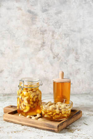 Board with sweet cashew nuts in honey on grunge backgroundの写真素材