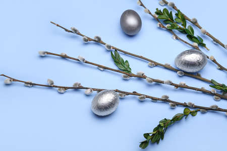 Easter eggs and pussy willow branches on blue background