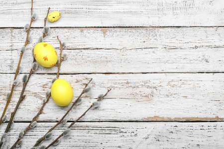 Painted Easter eggs and pussy willow branches on wooden background