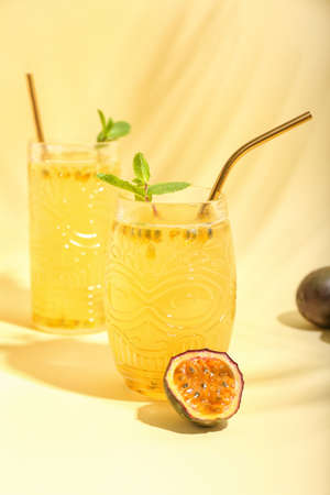 Glasses of delicious passion fruit juice on yellow backgroundの写真素材