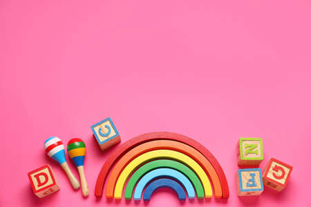 Wooden cubes with blocks and rattles on pink backgroundの写真素材