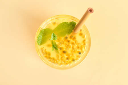 Glass of delicious passion fruit juice on yellow backgroundの写真素材