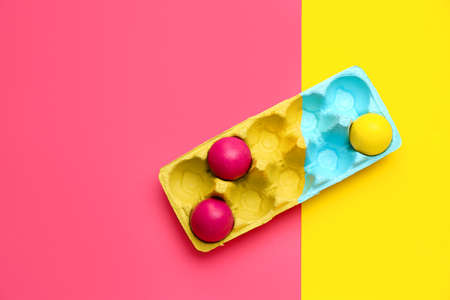 Holder with painted Easter eggs on color backgroundの写真素材