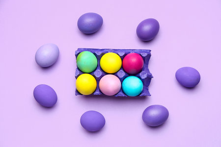 Holder with painted Easter eggs on color backgroundの写真素材