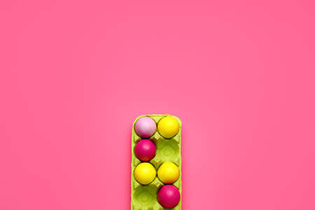 Holder with painted Easter eggs on color backgroundの写真素材