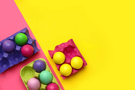 Holders with painted Easter eggs on color backgroundの写真素材