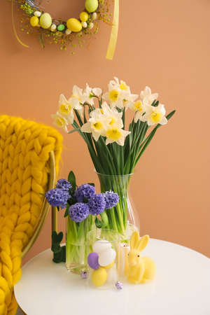 Easter decor and beautiful flowers on table near color wallの写真素材