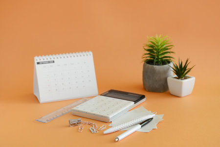 Different stationery and calendar on orange backgroundの写真素材