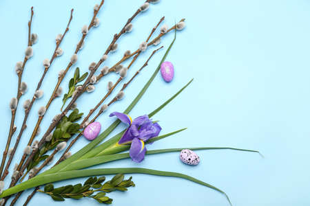 Willow branches, flower and painted Easter eggs on blue backgroundの写真素材