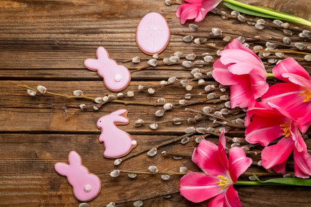 Willow branches, flowers and Easter cookies on wooden backgroundの写真素材