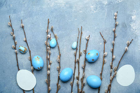 Willow branches, blank cards and painted Easter eggs on blue backgroundの写真素材