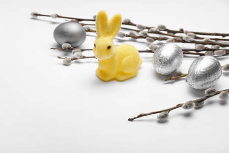 Willow branches, bunny and painted Easter eggs on light backgroundの写真素材