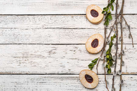 Willow branches and Easter cookies on light wooden backgroundの写真素材