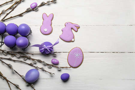 Willow branches, Easter cookies and painted eggs on light wooden backgroundの写真素材