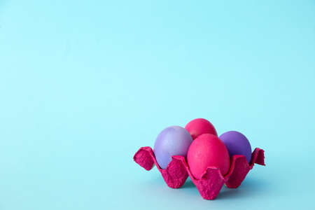 Holder with painted Easter eggs on color backgroundの写真素材