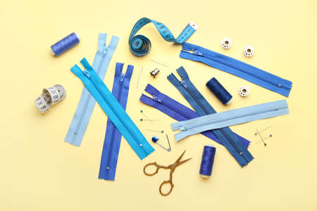 Set of colorful zippers and sewing supplies on beige backgroundの写真素材