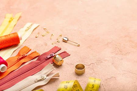 Set of colorful zippers and sewing supplies on beige backgroundの写真素材