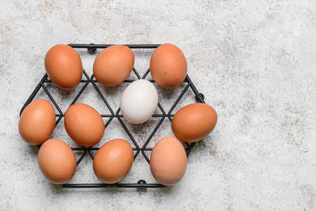 Grid with fresh chicken eggs on light background