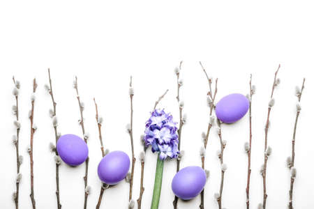 Painted Easter eggs, hyacinth flower and pussy willow branches on white background