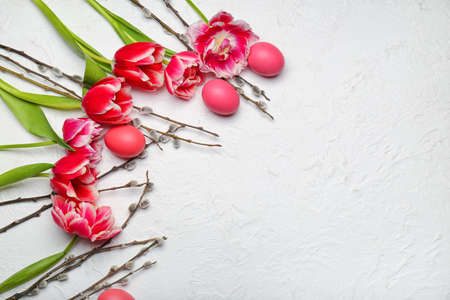 Pussy willow branches, painted Easter eggs and tulip flowers on light backgroundの写真素材