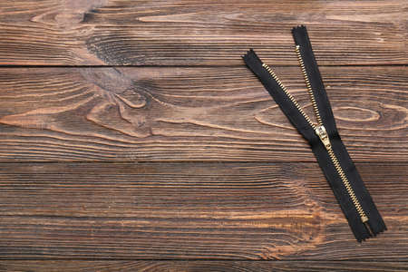 Stylish black zipper on wooden backgroundの写真素材