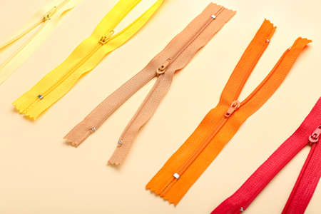 Stylish different zipper on beige backgroundの写真素材