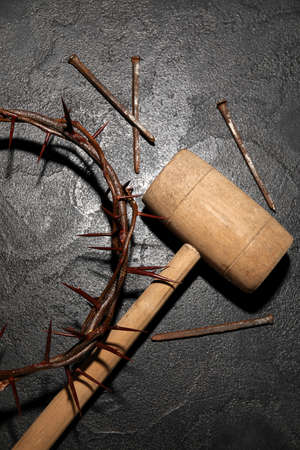Crown of thorns with mallet and nails on dark backgroundの写真素材
