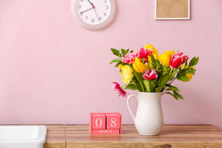 Vase with beautiful tulips and cube calendar with date 8 MARCH on kitchen counter. International Women's Day celebrationの写真素材