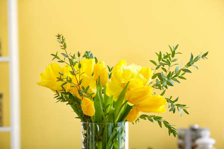 Vase with eucalyptus branches and tulips on yellow background, closeupの写真素材