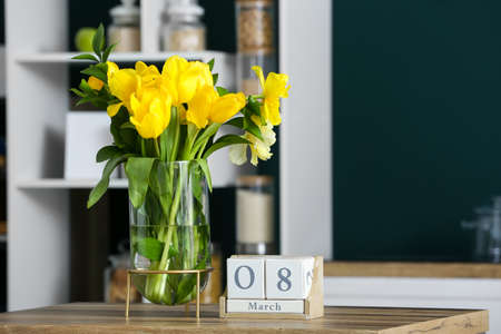 Vase with tulips and cube calendar with date 8 MARCH on wooden table. International Women's Day celebrationの写真素材