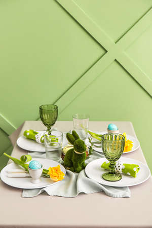 Table served for Easter celebration near green wallの写真素材