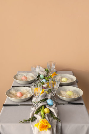 Table setting with Easter eggs and floral decor near color wall