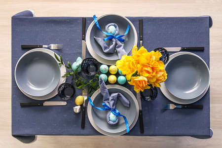 Beautiful table setting with bouquet of tulips and Easter eggs