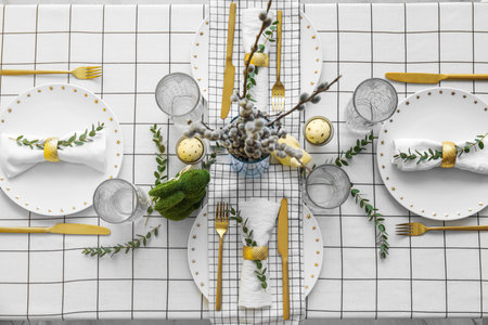 Table with beautiful setting for Easter celebration and eucalyptus branches