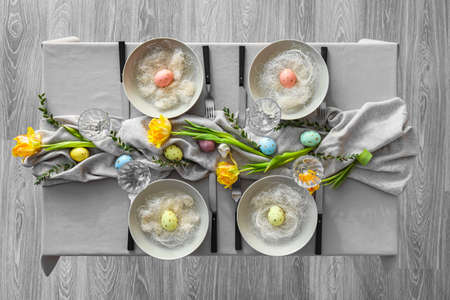 Stylish table setting with floral decor and Easter eggs