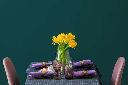Stylish setting with tulips on served table near green wallの写真素材