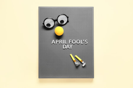 Gray board with text APRIL FOOL'S DAY and party set on yellow backgroundの写真素材